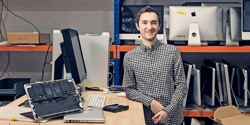 CEO & Gründer von Revendo, Aurel Greiner, steht lächelnd vor der Kamera in seinem Büro